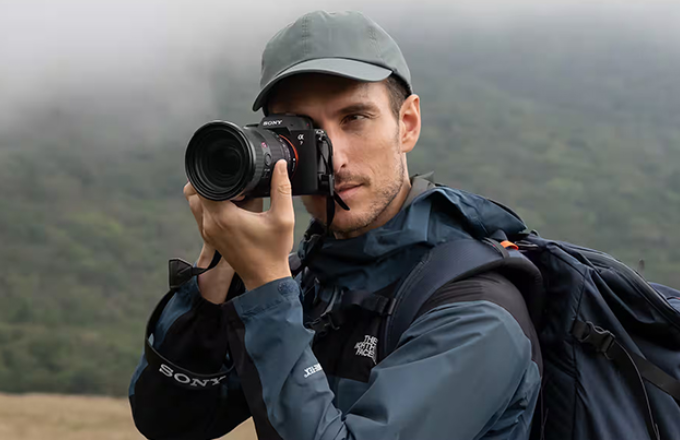 登山者手拿單眼相機A7M5拍照